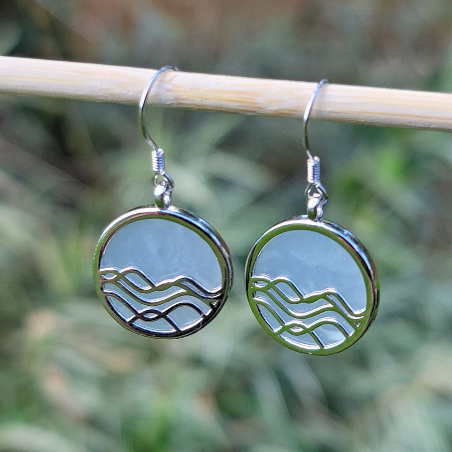 amazonite gemstone earrings. silver dangle earrings with ocean wave design with greenery in background