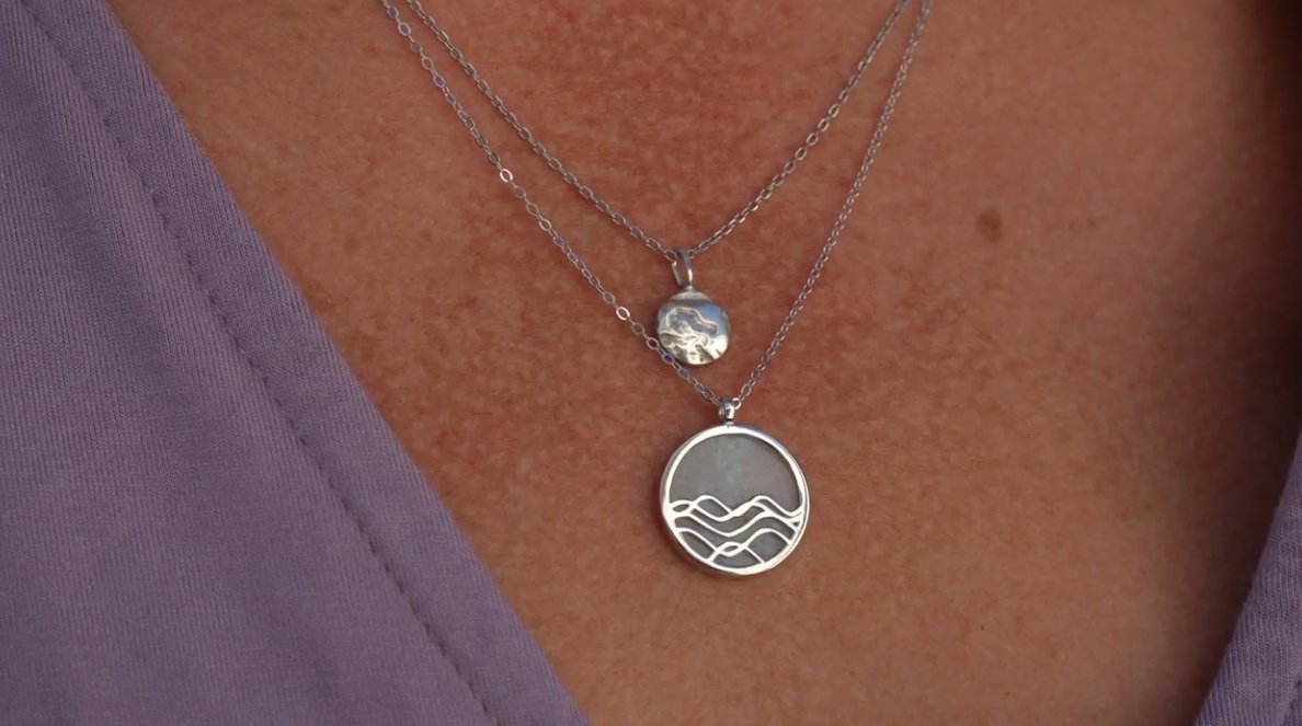 close up of model wearing layered silver necklace stack. silver circle pendant necklaces.