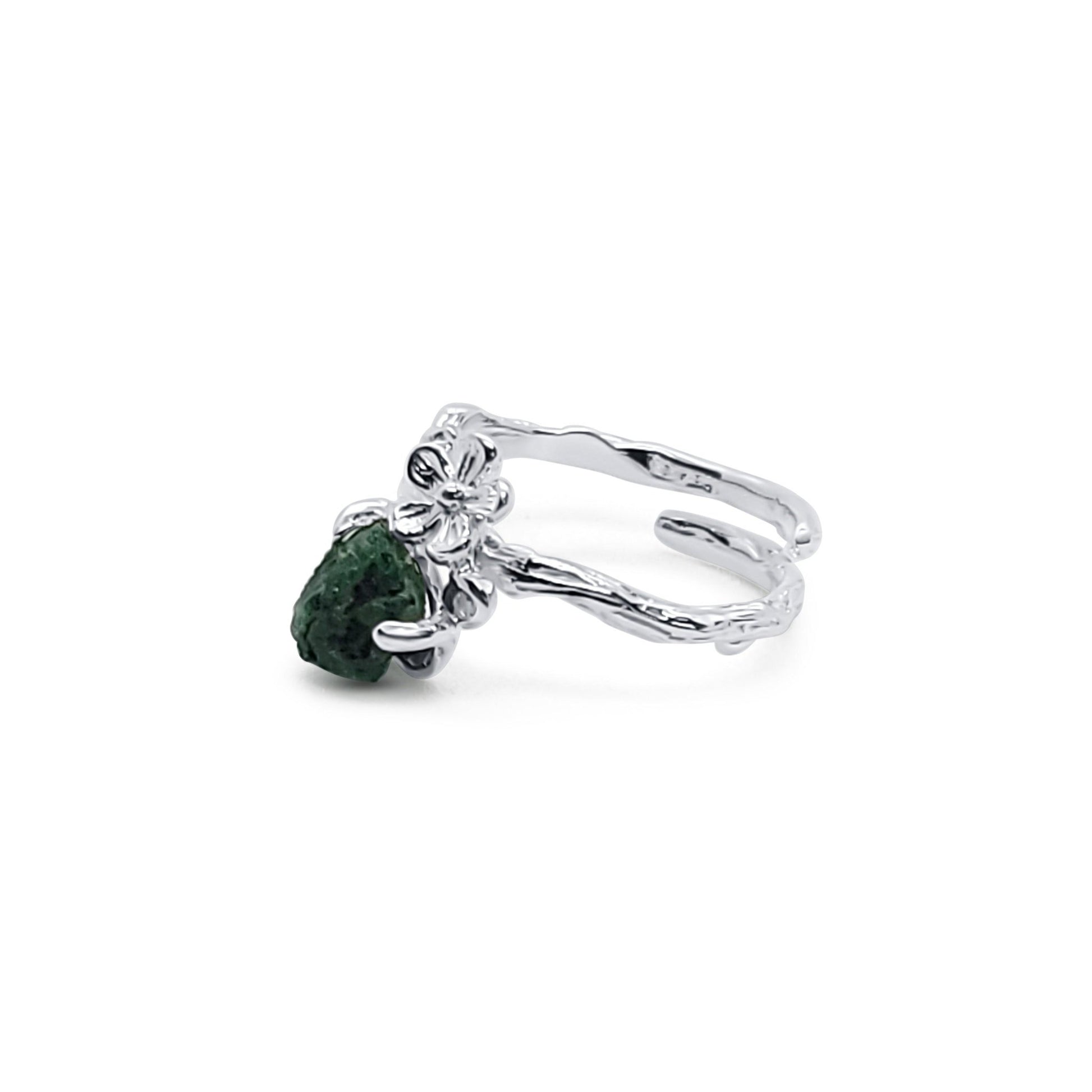 side view of sterling silver flower ring with raw emerald stone in prong setting