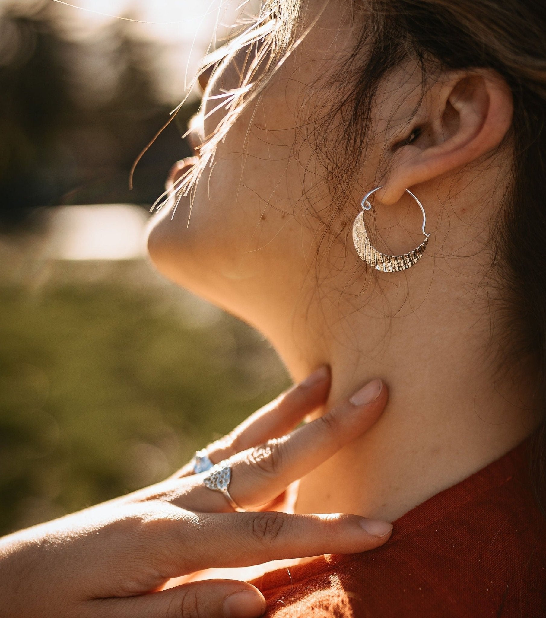 model wearing crescent moon silver hoop earring with seashell texture