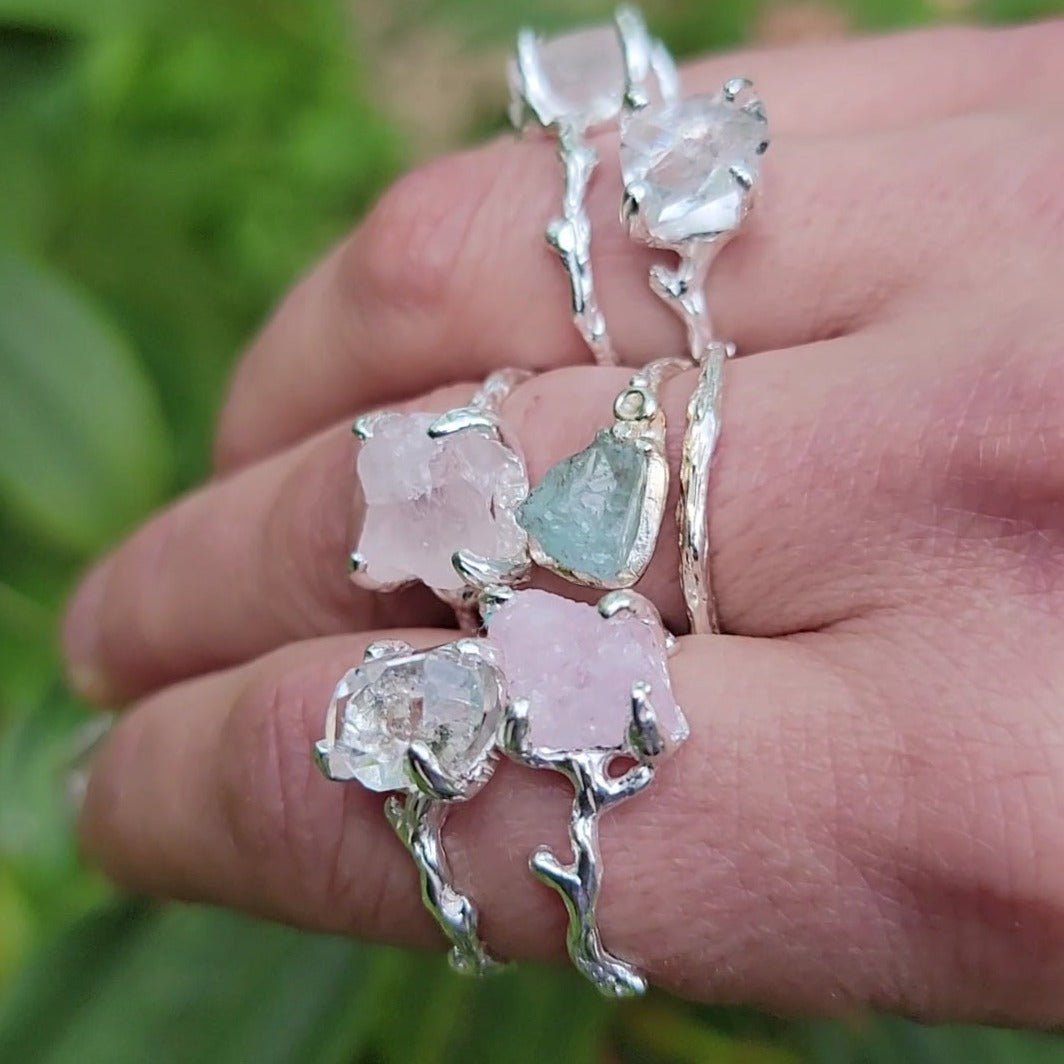 hand wearing multiple raw gemstone rings -  rose quartz, Herkimer diamond and aquamarine