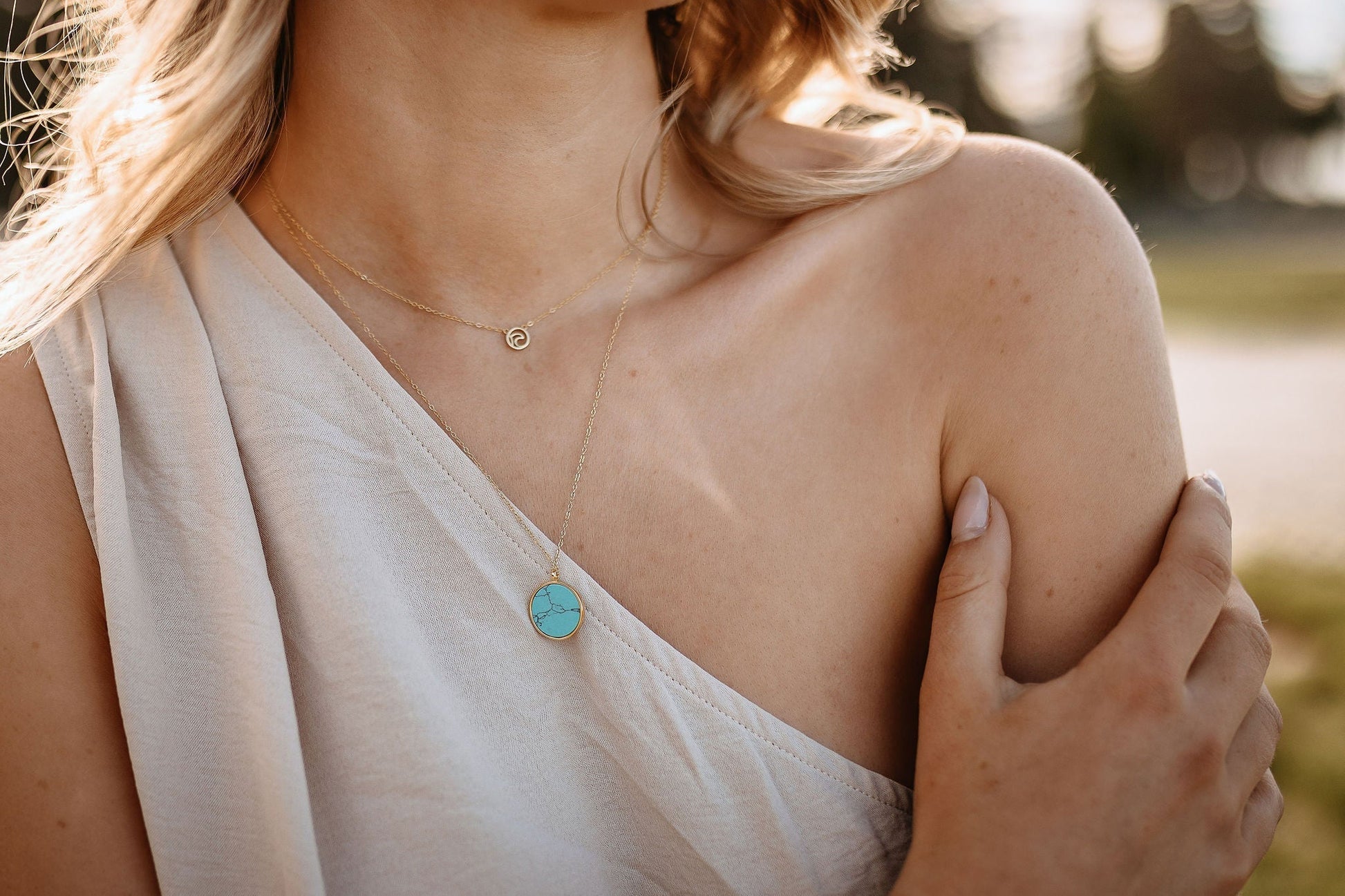 model wearing small surf wave adjustable necklace in gold layere with reversible turquoise circle necklace